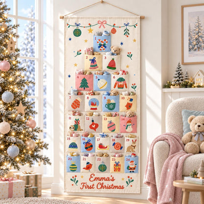 May include: A hanging fabric advent calendar with twenty-four numbered pockets arranged in a tree shape. The cream-colored canvas features colorful holiday illustrations on each pocket and the text Emma's First Christmas at the bottom.